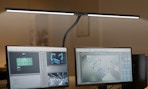 a desk lamp over two monitors 
