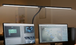 a desk lamp over two monitors 