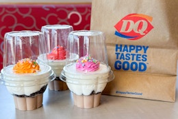 three dairy queen ice cream cupcakes on a table next to a dq top go bag