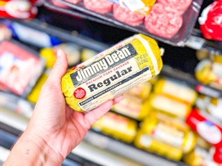hand holding a roll of jimmy dean sausage in walmart aisle