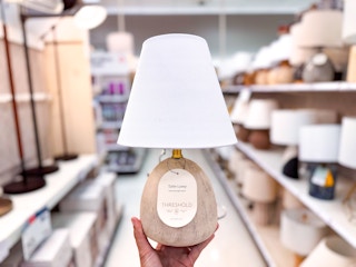 hand holding a natural wood table lamp