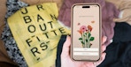 Someone holding a phone displaying the Anthropologie app next to an Urban Outfitters bag
