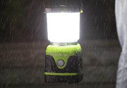 a person holding a camping lantern