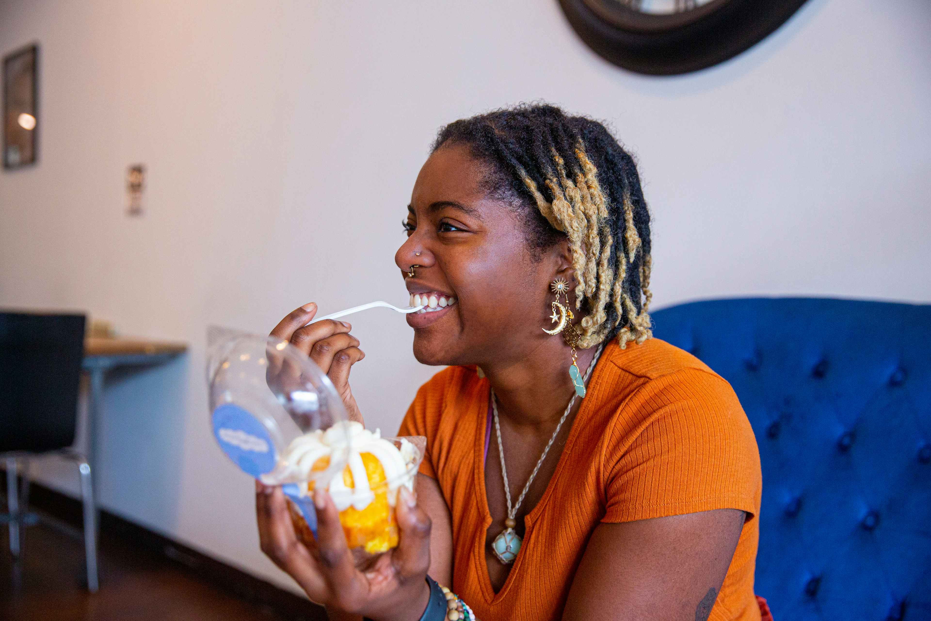 Person smiling while eating a bundtlette cake 