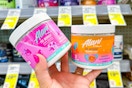 person holding 2 tubs of alani nu pre workout