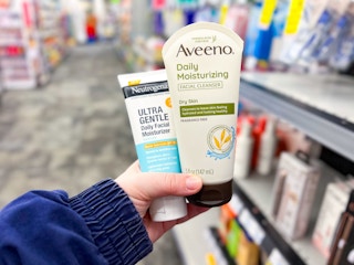 hand holding aveeno and neutrogena skincare products