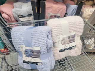 two knit throw blankets in a cart