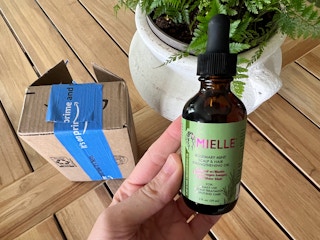 hand holding mielle hair oil