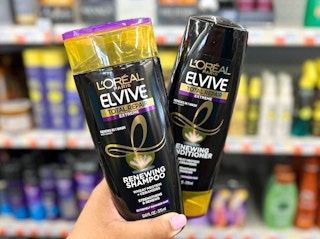 hand holding two bottles of L'Oreal Elvive shampoo and conditioner
