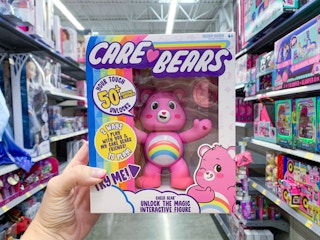 care bear cheer bear interactive toy held up in front of other toys