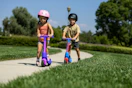 lifestyle image of children riding scooters on a sidewalk