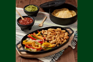 a cast iron 8-piece fajita set on a table with food 