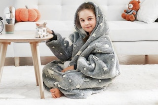 kid sitting on floor with a blanket hoodie on