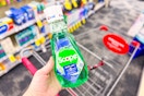 person holding a bottle of scope mouthwash over a cart