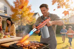 man using torch gun on grill