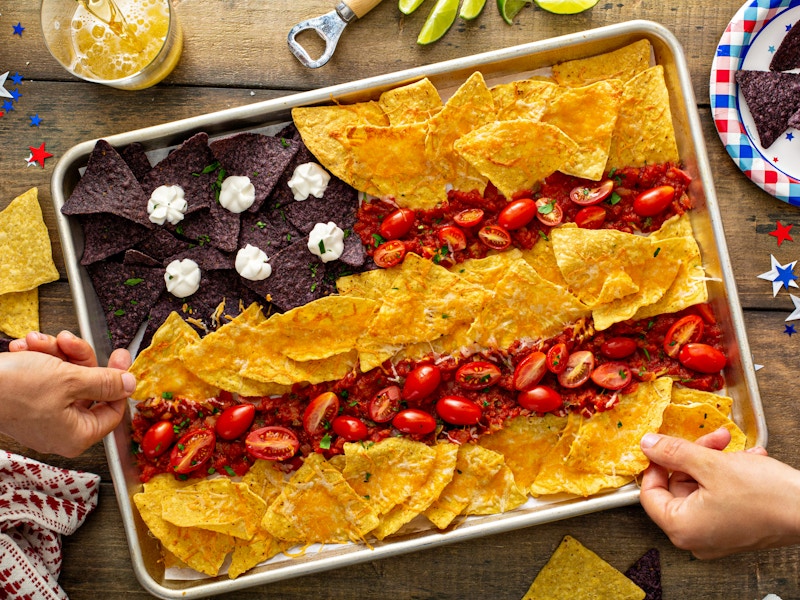 Some nachos in a shape of american flag on a tray for 4th of July