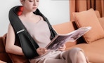a person wearing a neck massager on a couch