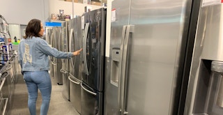 a person looking at fridges at best buy