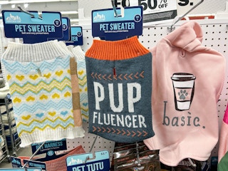 pet hoodies and sweaters on hangers in store