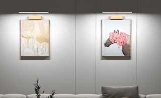 a gold light fixture on a wall over a desk