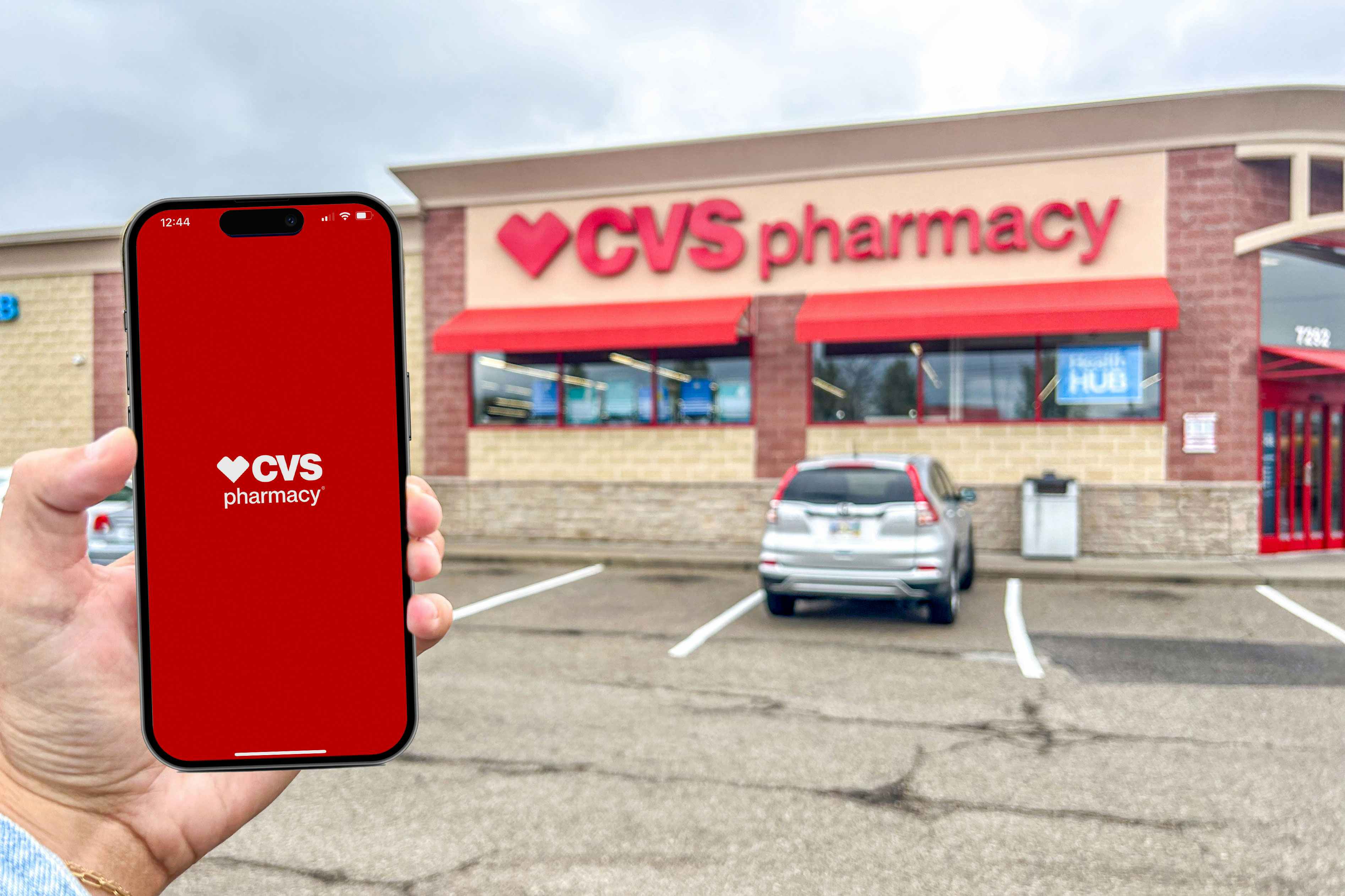 a person holding up an iphone in front of a cvs store 