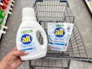 hand holding all detergent and all mighty pacs in cart
