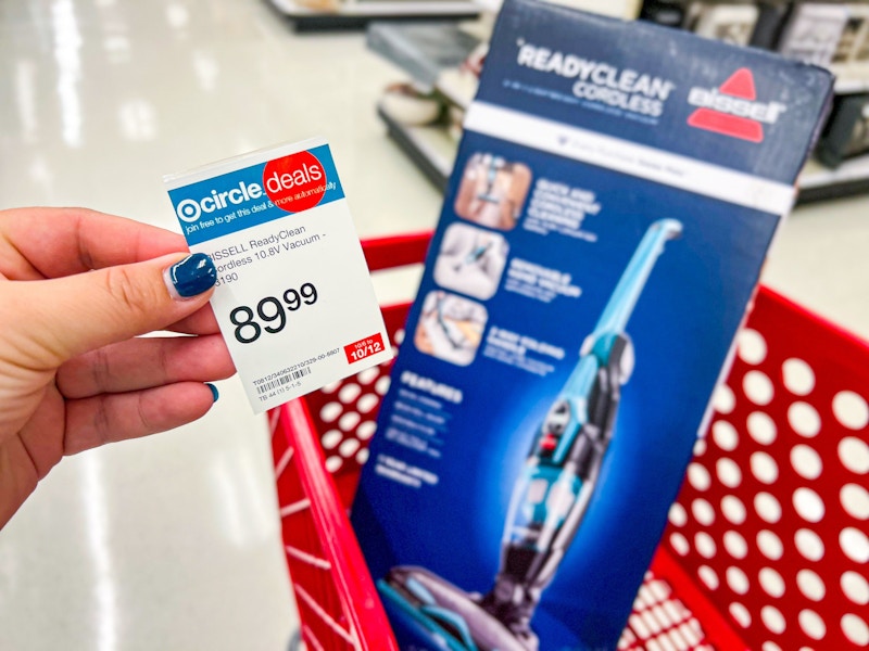 hand holding sale sign and bissell readyclean vacuum in target cart