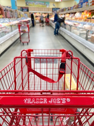A shopping cart in the center of an aisle at Trader Joe's