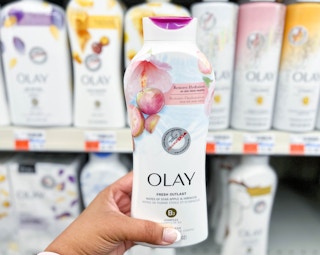 hand holding Olay body wash in front of Olay display