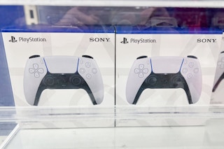 White Playstation DualSense Controllers behind glass display in stores at Target in electronic section
