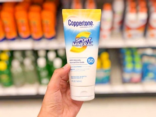 hand holding a bottle of coppertone mineral sunscreen at target