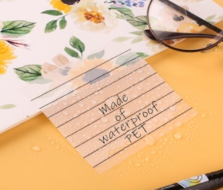 a transparent sticky note on a floral notebook