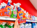 hand holding tide laundry stain remover in front of a target shelf