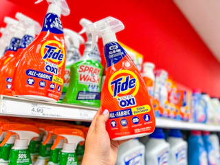hand holding tide laundry stain remover in front of a target shelf