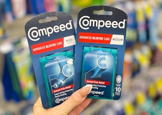 hand holding two packages of compeed advanced blister care