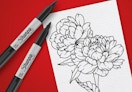 Sharpie markers next to a drawing on a red background