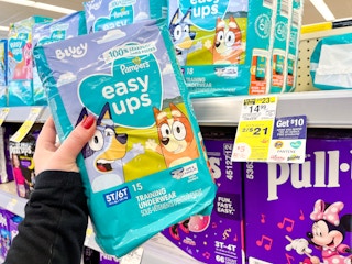 person holding a package of pampers easy ups