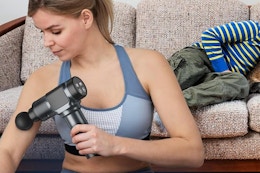 a woman using a massage gun