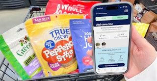 A phone displaying the new Petco rewards program membership in front of a cart of pet supplies