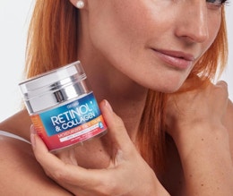 a person holding a jar of retinol cream