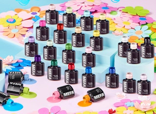 colorful nail polish in black bottle on colorful stands with flowers