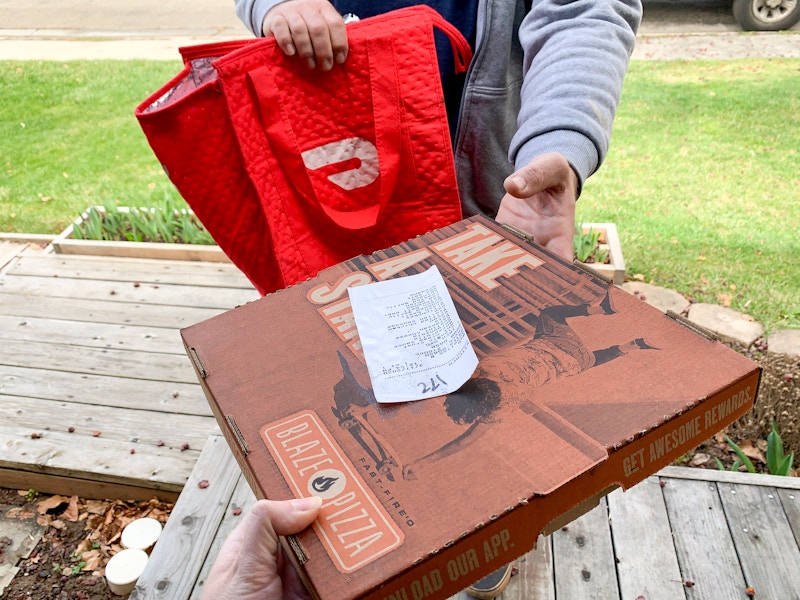 Doordash delivery person delivering a pizza.