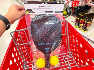 holding up pickleball set over the top of a Target shopping cart