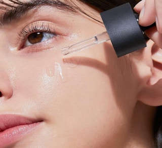 a person applying face serum on their face