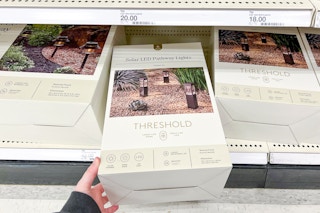 hand grabbing a threshold path lights set off a target shelf