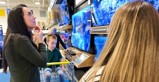 People looking at TVs on display in Best Buy