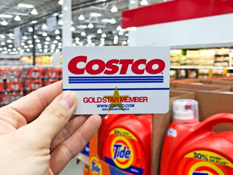 Someone holding their Costco Gold Star Member card inside Costco