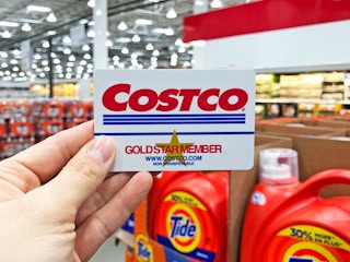 Someone holding their Costco Gold Star Member card inside Costco
