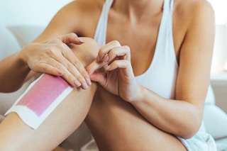 a woman using a wax strip