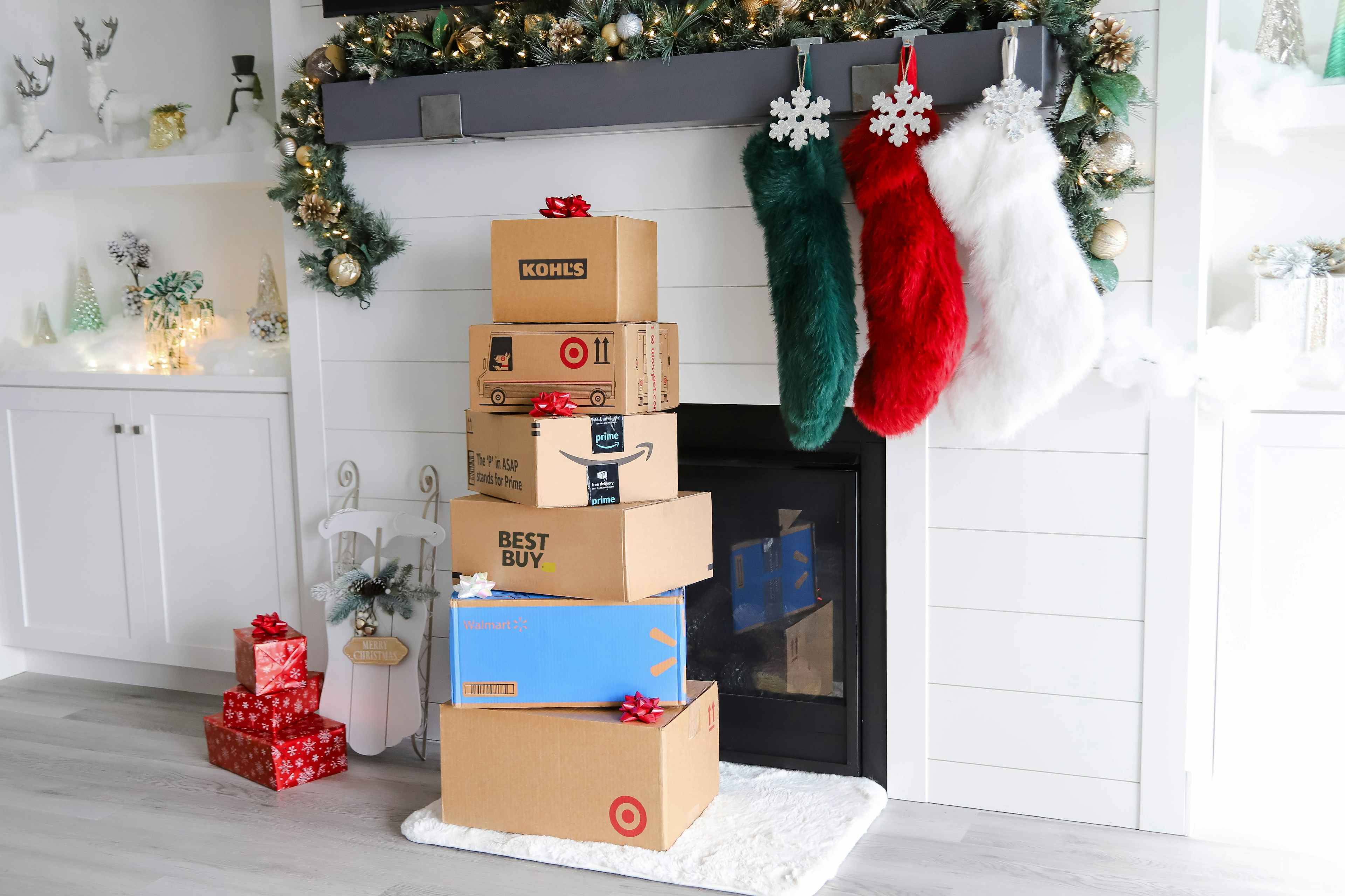 a stack of boxes near a fireplace decorated for the holidays
